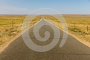 Asphalt road in the steppe with wind generators on the horizon, Inner Mongolia