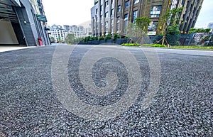 Asphalt road surface with cityscape background, closeup of photo