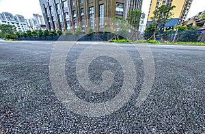 Asphalt road surface with cityscape background, closeup of photo