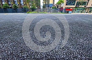 Asphalt road surface with cityscape background, closeup of photo