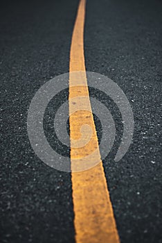 Asphalt road surface texture with a yellow line.