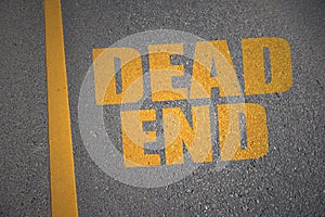 Asphalt road with text dead end near yellow line.