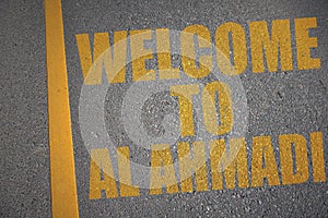 asphalt road with text welcome to Al Ahmadi near yellow line photo