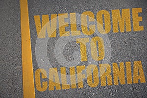 asphalt road with text welcome to california near yellow line