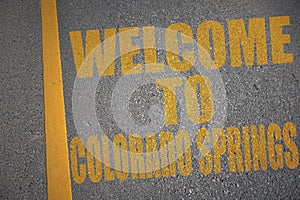 asphalt road with text welcome to colorado springs near yellow line