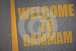 asphalt road with text welcome to Dammam near yellow line photo