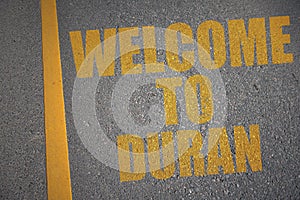 asphalt road with text welcome to Duran near yellow line