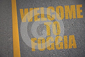 asphalt road with text welcome to Foggia near yellow line