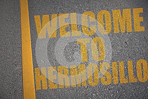 asphalt road with text welcome to Hermosillo near yellow line photo