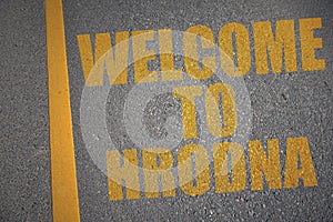 asphalt road with text welcome to Hrodna near yellow line