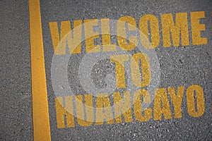 asphalt road with text welcome to Huancayo near yellow line photo