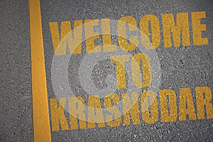asphalt road with text welcome to Krasnodar near yellow line