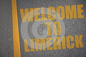 asphalt road with text welcome to Limerick near yellow line