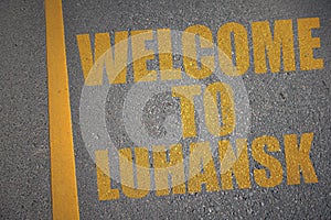 asphalt road with text welcome to Luhansk near yellow line photo