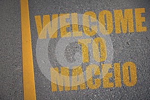 asphalt road with text welcome to Maceio near yellow line