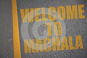 asphalt road with text welcome to Machala near yellow line