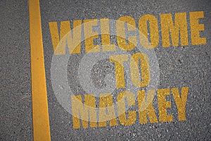 asphalt road with text welcome to Mackay near yellow line