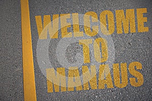 asphalt road with text welcome to Manaus near yellow line