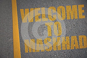 asphalt road with text welcome to Mashhad near yellow line photo