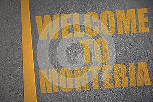asphalt road with text welcome to Monteria near yellow line photo