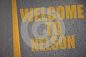 asphalt road with text welcome to Nelson near yellow line