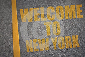 asphalt road with text welcome to new york near yellow line.