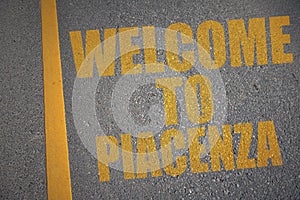 asphalt road with text welcome to Piacenza near yellow line