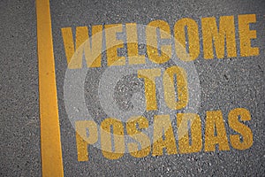 asphalt road with text welcome to Posadas near yellow line