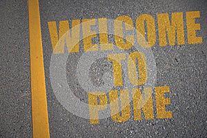 asphalt road with text welcome to Pune near yellow line