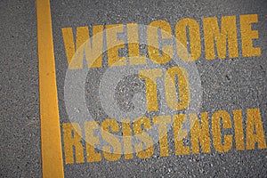 asphalt road with text welcome to Resistencia near yellow line photo