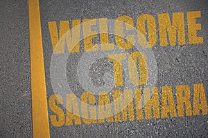 asphalt road with text welcome to sagamihara near yellow line