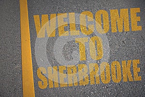 asphalt road with text welcome to Sherbrooke near yellow line