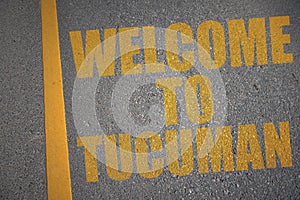 asphalt road with text welcome to tucuman near yellow line