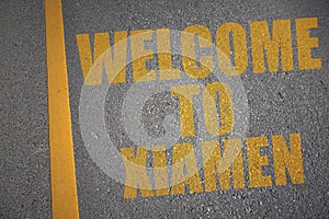 asphalt road with text welcome to Xiamen near yellow line