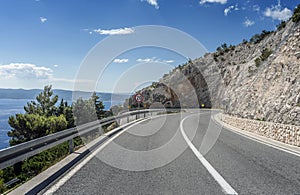 Asphalt road to the sea. Asphalt highway in a sunny day.