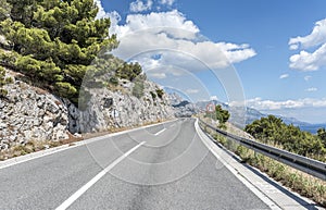 Asphalt road to the sea. Asphalt highway in a sunny day.