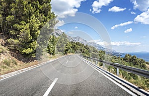 Asphalt road to the sea. Asphalt highway in a sunny day.