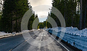 Asphalt road to Yellowstone National Park cleared of snow in early spring, US