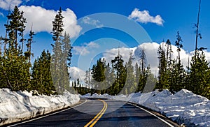 Asphalt road to Yellowstone National Park cleared of snow in early spring, US