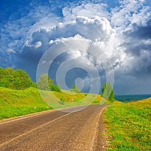 asphalt road under a dense cloudy sky