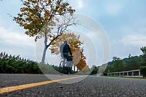 Asphalt road on which a cyclist rides. Autumn bike ride