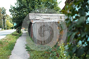 Asphalt road and wooden fence, private houses within the city, selective focus