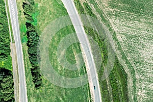 Asphalt roads pass through green countryside landscape. aerial view