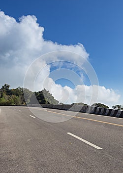 Asphalt roadway with cloud blue sky