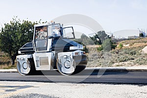 Asphalt roller compactor machine working on the paving of a road