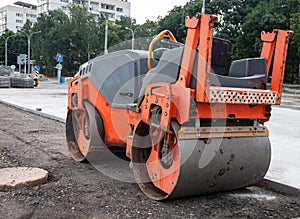 The asphalt roller compresses the soil by squeezing it with its own weight.