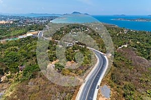 Asphalt rural road curve on high mountain with tropical sea in phuket Thailand image by Drone camera High angle view