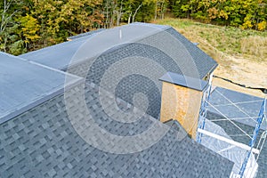 An asphalt shingle roof covers roof of a newly built house