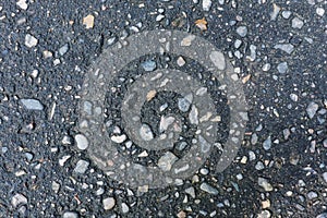 Asphalt with stones or textured concrete wall, gray with blue tint. Closeup of city sidewalk, pavement, urban architecture.