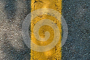 Asphalt texture with a yellow dividing strip. Top view